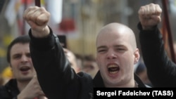 Участник акции националистов "Русский марш" на одной из улиц города. Россия, 2013 год