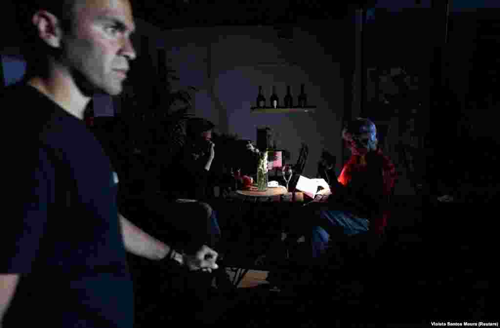 Люди сидять у ресторані без світла і підсвічують собі мобільними телефонами, Мадрид, Іспанія, 28 квітня 2025 року