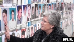 Nesrete Kumnova u Prištini ispred zida na kome se nalaze fotografije nestale djece, novembar 2007. godina