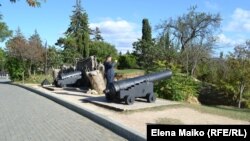 Турист фотографирует корабельные пушки на Малаховом кургане