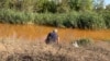 Рыбак на берегу Камышевахи, куда сливают шахтные воды. Они пришли с оккупированной территории и переполнили шахту в подконтрольном Украине Золотом. Сентябрь 2021 года