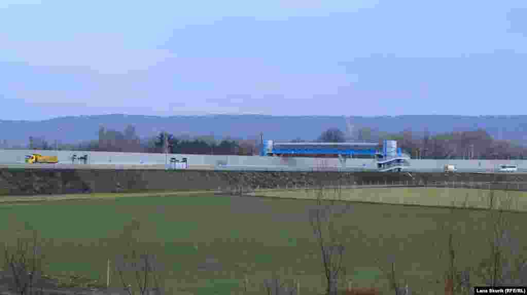 Трассу «Таврида» отделяет от села шумозащитный забор, перейти дорогу можно по надземному переходу, который находится в полукилометре от северо-восточной окраины села