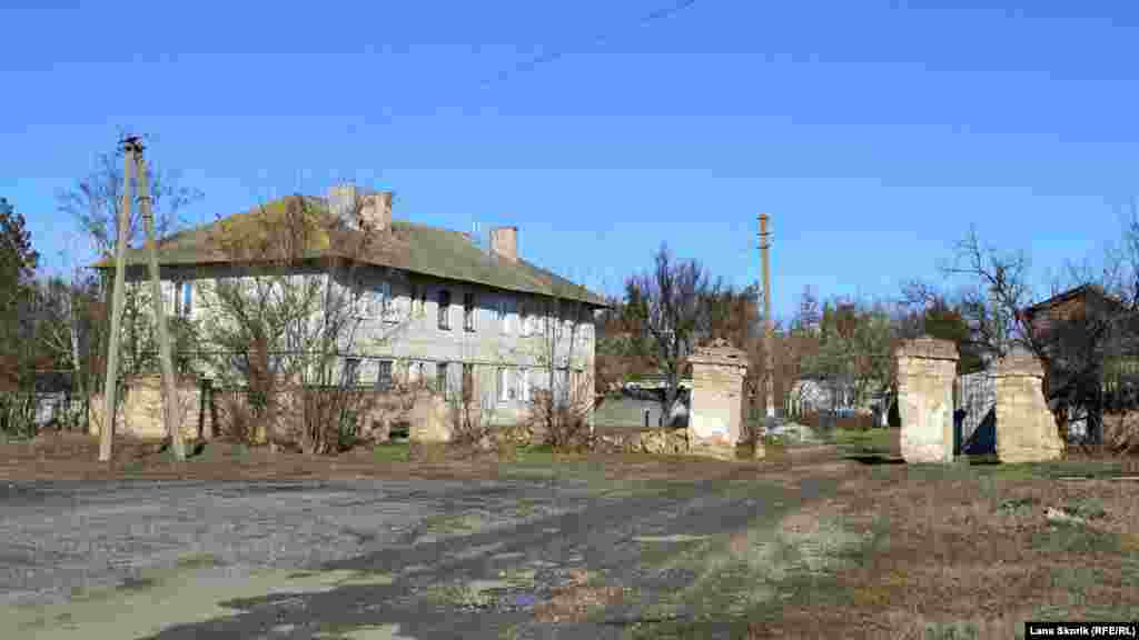 Двухэтажный дом рядом с трассой построен организацией с аббревиатурой «ДПР №28» еще до образования села