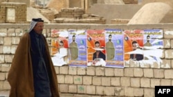 Election posters on a wall at Al-Najaf cemetery in Iraq