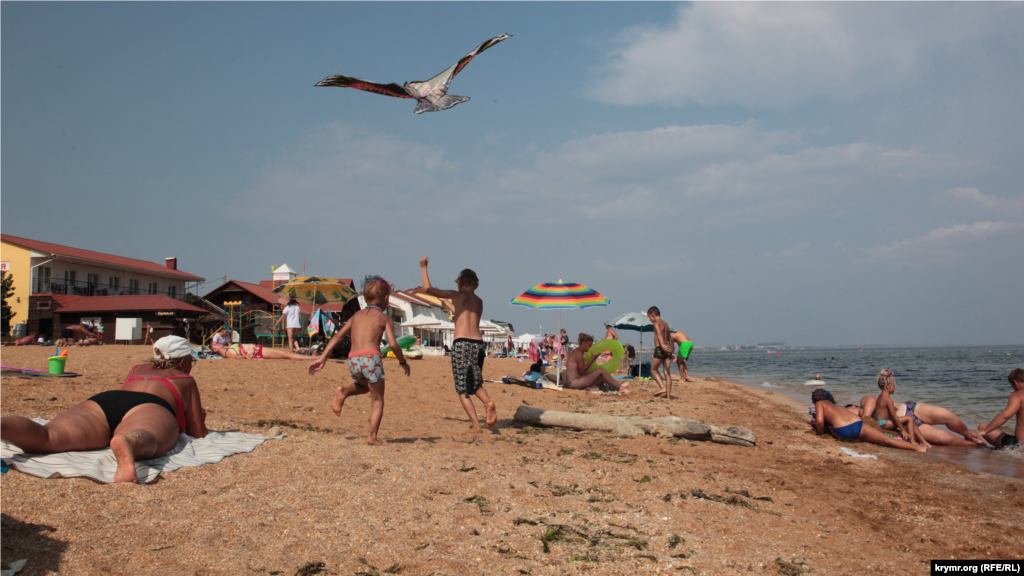 Дети запускают воздушного змея на «Золотом пляже» в Феодосии. Как проходили последние дни августа на берегу Черного моря в Феодосии – в фоторепортаже Крым.Реалии  
