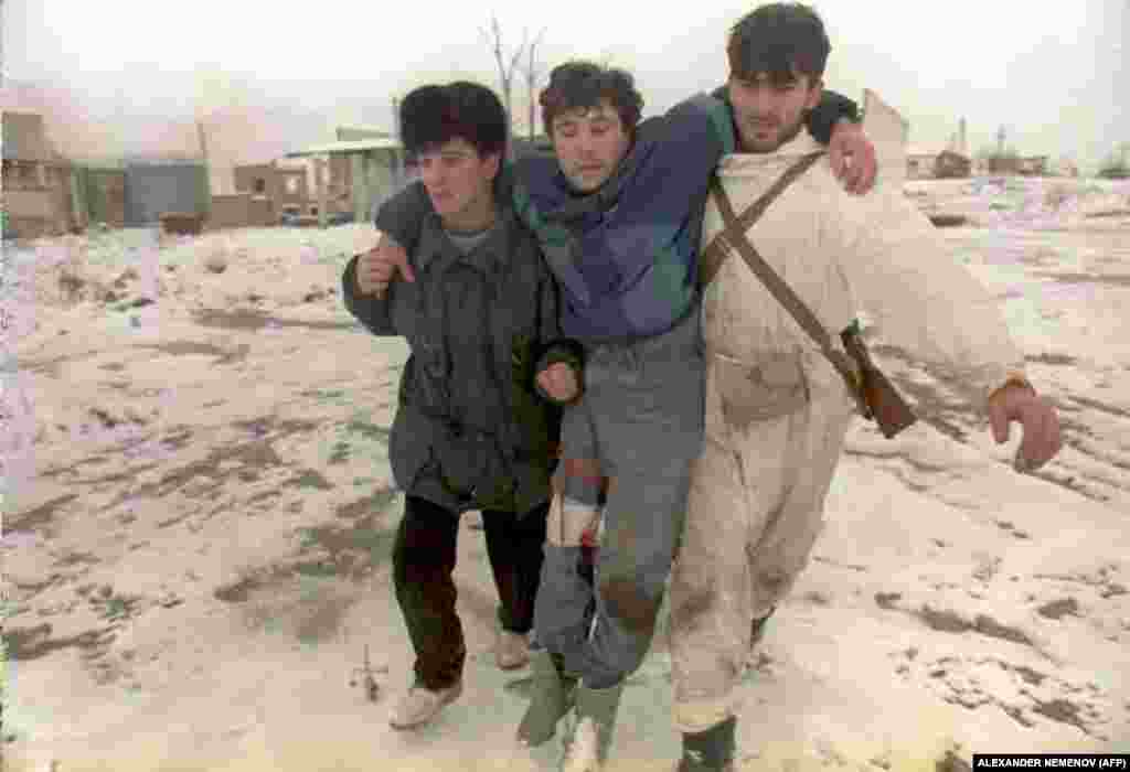 Російські війська продовжують інтенсивні бомбардування і ракетні обстріли Грозного. У чеченських бійців на озброєнні були тільки кулемети і гранати. Дуже багато загиблих і поранених. Два бійці виводять з центру міста на околицю пораненого товариша. 25 грудня 1994 року