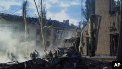 Рятувальники розчищають завали після обстрілу російськими балістичними ракетами в Києві, 24 квітня 2025 року