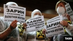 Protesters hold placards during a rally by foreign-currency mortgage holders at Raiffeisen Bank in Moscow in February last year.