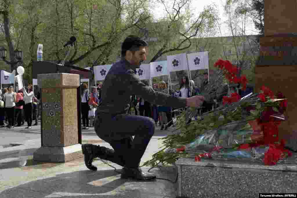 Цветы к "Хачкару" несли люди всех возрастов, одни просто возлагали цветы и уходили, а другие подолгу задерживались у памятника на коленях.