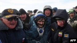 Ailing? Russian space agency rescuers help cosmonaut Aleksandr Kaleri shortly after his landing near the town of Arkalyk, in Kazakhstan on March 16.