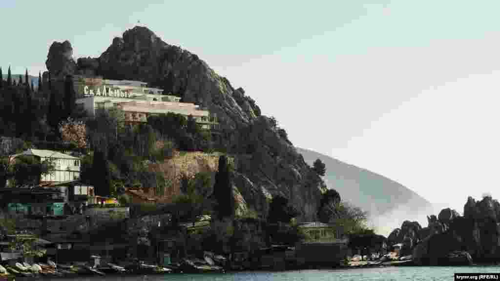 Скалистый берег – одна из отличительных особенностей Южного берега Крыма. Местные жители готовят лодки в ожидании теплой погоды. Над Чеховским пляжем возвышается гостиница «Скальная»