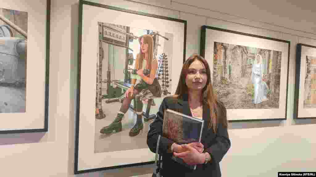 Ветеранка Руся Данілкіна фотографується на фоні власної світлини. Дівчина у 18 років пішла на фронт, у 19 через поранення уламком касетного боєприпасу втратила ногу. Дівчина мотивує людей з ампутаціями жити повним життям і працює у реабілітаційному центрі для ветеранів Superhumans Cente