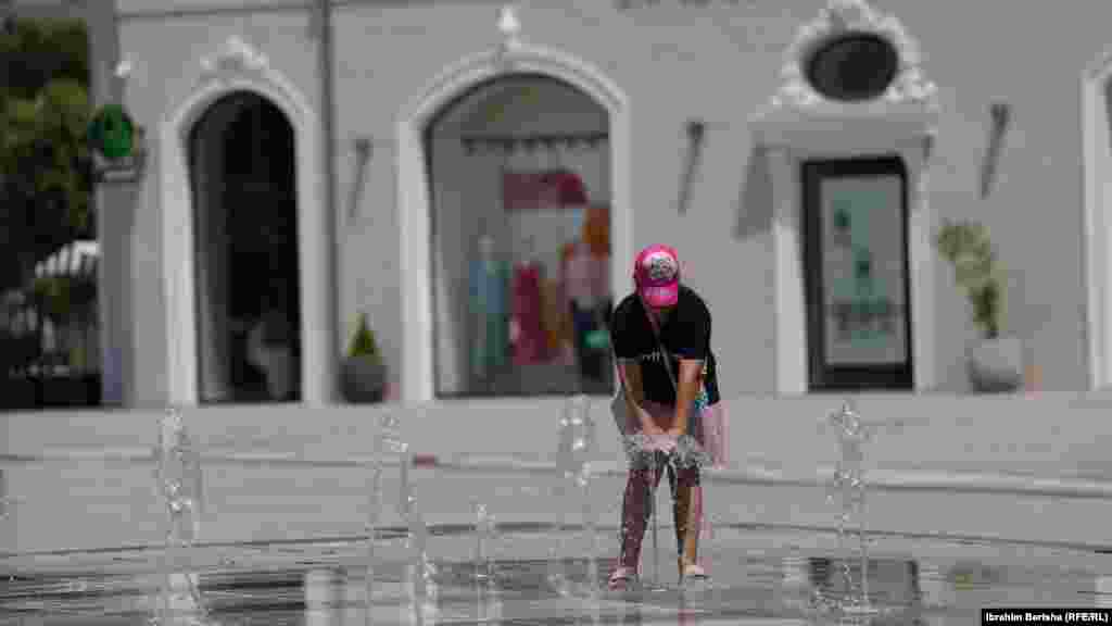 Stanovnica Prištine se rashlađuje u fontani u glavnom gradu Kosova, gdje su temperature 26. juna dostigle 36 stepeni Celzijusa.