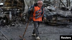 A Ukrainian municipal worker cleans an area at the site of a Russian drone strike on Dnipro on April 9.