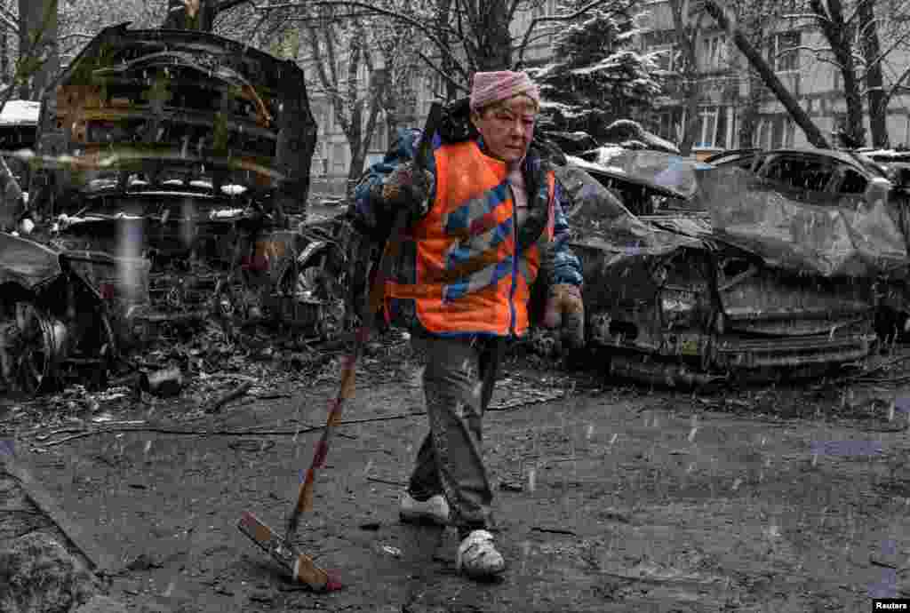 Коммунальный рабочий убирает территорию на месте удара российского дрона во время атаки России на Украину. Днепр, Украина, 9 апреля 2025 года. REUTERS/Mykola Synelnykov