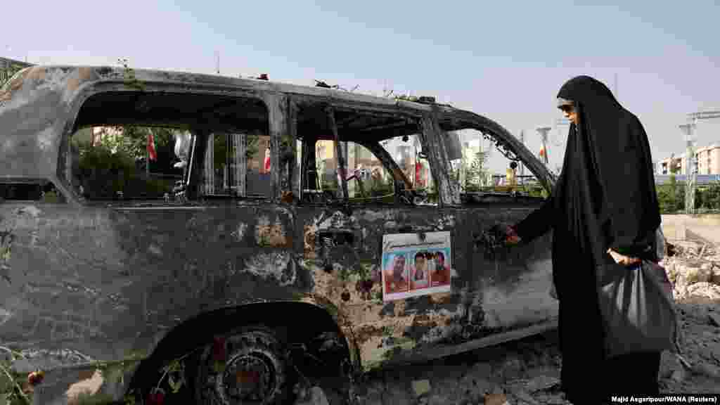 Iranska žena gleda u ambulantno vozilo spaljeno u izraelskim napadima na Teheran tokom 12-dnevnog sukoba između dve zemlje.