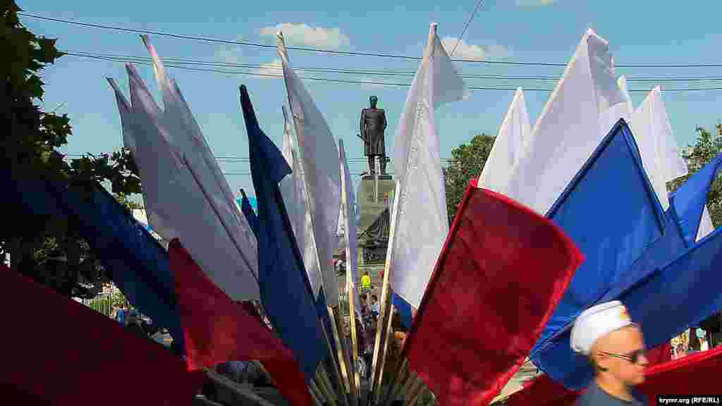 Сквозь «букет» из флагов виднеется памятник Нахимову