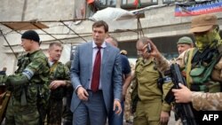 Народний депутат України Олег Царьов (другий ліворуч) стоїть поряд із бійцями збройного формування – батальйону «Схід» – біля штаб-квартири підконтрольного Росії угруповання «ДНР» у Донецьку, 12 червня 2014 року