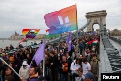 Протестувальники несуть прапори під час демонстрації після того, як угорський парламент проголосував за конституційні поправки, спрямовані проти ЛГБТК+ спільноти, Будапешт, Угорщина, 14 квітня 2025 року