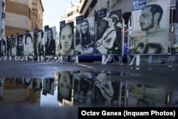 Fotografiile victimelor incendiului de la Clubul Colectiv sunt expuse în fața fostului sediu al clubului din București.