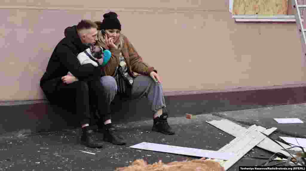 Пара місцевих мешканців з домашнім улюбленцем під стінами власного під'їзду, що зазнав руйнувань через ракетний удар російських військ. Запоріжжя, 18 січня 2025 року  