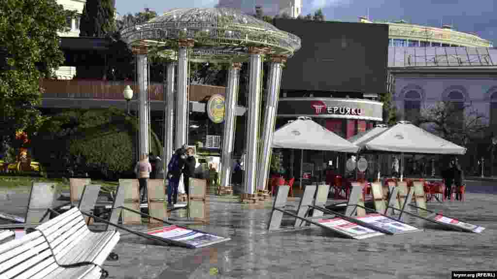 На набережной Ялты стихия опрокинула стенды уличной фотовыставки возле памятника Ленину. Установленную там ротонду покосило