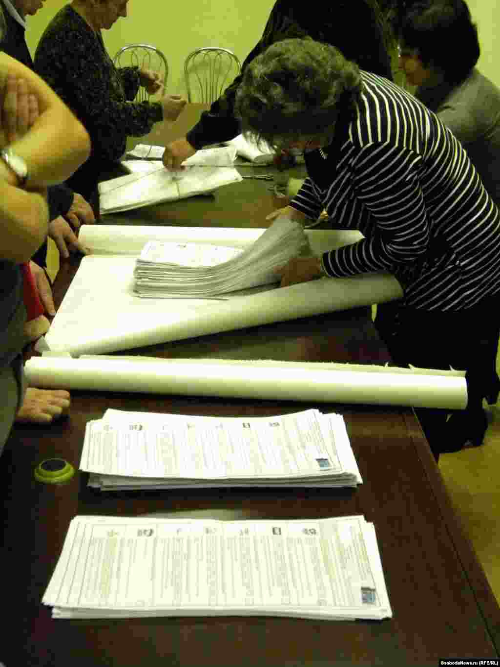 Настоящая разница в толщине между стопками "Единой России" и "Яблока" была видна невооруженным глазом (члены УИК запаковывают бюллетени "ЕР", на переднем плане - стопка "Яблока" и испорченных бюллетеней)