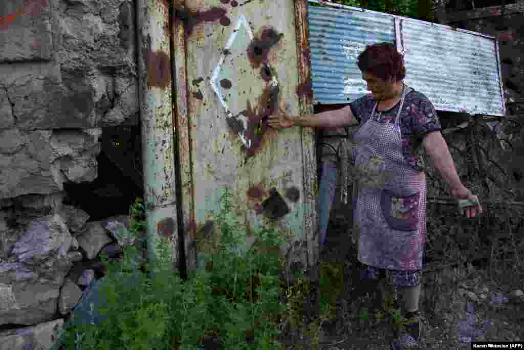 Жінка на своєму подвір'ї показує сліди від обстрілу. Село Айгепар, Вірменія 