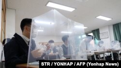 Cтуденти за захисним щитом під час поновлення навчання в Південній Кореї