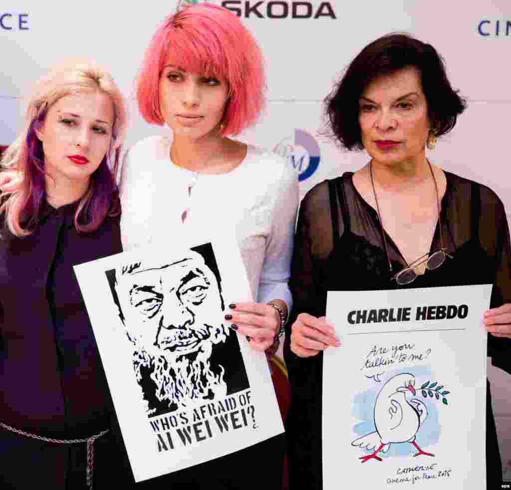 Мария Алехина, Надежда Толоконникова и Бьянка Джаггер демонстрируют карикатуры из журнала  Charlie Hebdo. Девушки из группы Pussy Riot были участницами мероприятия «Кино за мир», проводившегося в рамках Берлинале