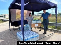 Пункт раздачи воды российским туристам, застрявшим в пробках у Керченского моста во время курортного сезона, 14 июля 2025 год