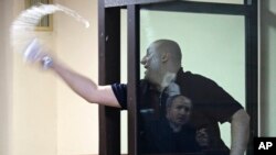 Opozantul Nika Melia, unul din liderii Coaliției pentru Schimbare, văzut aici cum aruncă cu apă spre un judecător, este unul din șase activiști condamnați la închisoare săptămâna trecută, alți doi politicieni ai opoziției pro-occidentale așteptându-și încă sentințele.