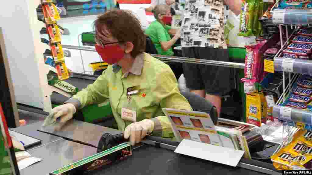 Продавцы на кассах в торговом центре – в защитных масках и перчатках