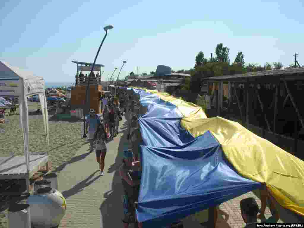 В День Независимости Украины от территории «Джаз Коктебель» и через всю набережную поселка отдыхающие и гости фестиваля растянули украинский флаг длинной в один километр