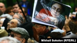 Участник мероприятия на седьмую годовщину убийства Политковской держит в руках ее портрет