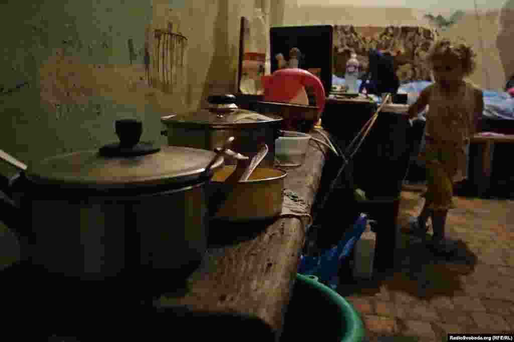 Електричні кабелі підведені до укриття та під’єднані до плити та чайника в імпровізованій кухні підвалу.