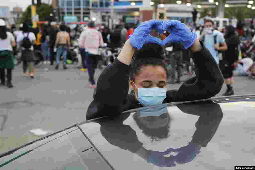 Знак «Я люблю вас» від учасниці акції для усіх протестувальників, які беруть участь у протесті після комендантської години. Міннеаполіс, штат Міннесота. 31 травня 2020 року (Фото AP/Julio Cortez)