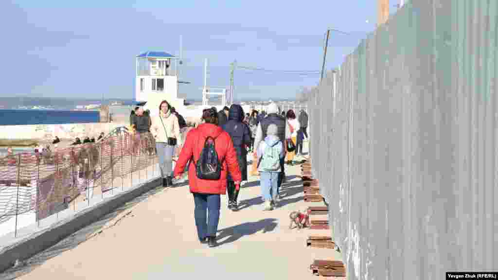 Прогуливаться по набережной гражданам приходится вдоль строительного забора 