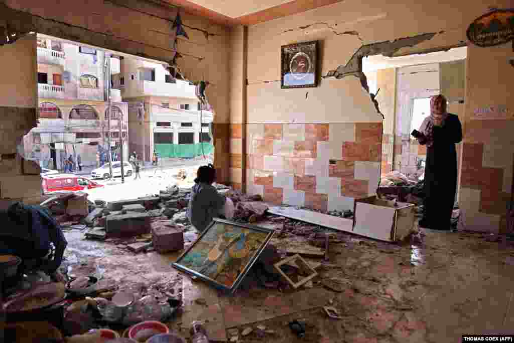 Діти палестинця Мансура Абу Гадьяна, який зараз проживає зі своєю сім’єю в школі, що управляється Близькосхідним агентством ООН із надання допомоги палестинським біженцям та організації робіт (UNRWA), оглядають їхній будинок, пошкоджений під час протистояння, в місті Газа, 29 травня 2021 року