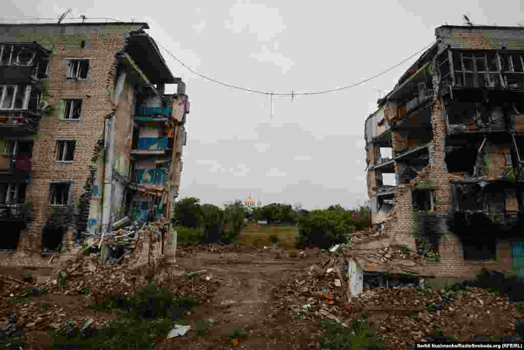 9 березня 2022 року російські військові завдали авіаудару по житловому будинку №2 по вулиці Першотравнева. В результаті загинуло щонайменше 44 людини, вересень 2022 року / Праворуч: початок жовтня 2024-го Першотравневу після деокупації міста перейменували на вулицю Пам'яті