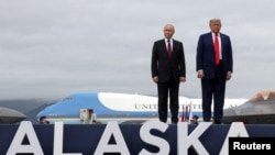 Președintele rus Vladimir Putin și președintele american Donald Trump pozează pe un podium pe pista de aterizare după ceu au sosit pentru discuții la baza militară Elmendorf-Richardson din Anchorage, Alaska, SUA, 15 august 2025.