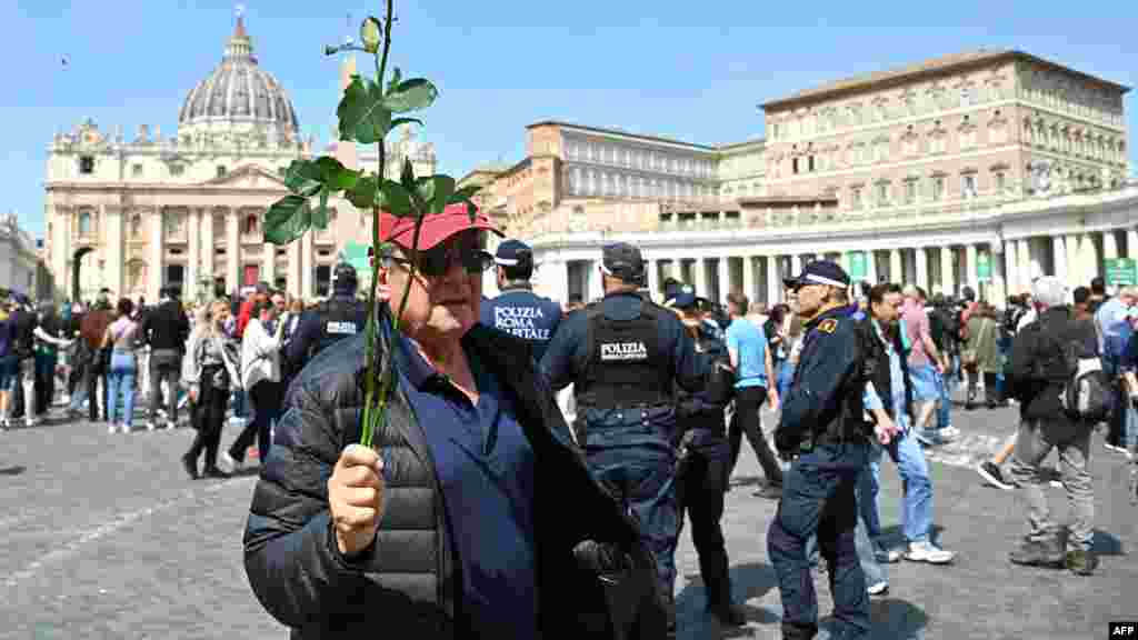 Човек со бела роза, дојден да му оддаде почит на папата Франциск, кој почина еден ден откако им се обрати на верниците на истото место по повод Велигден.