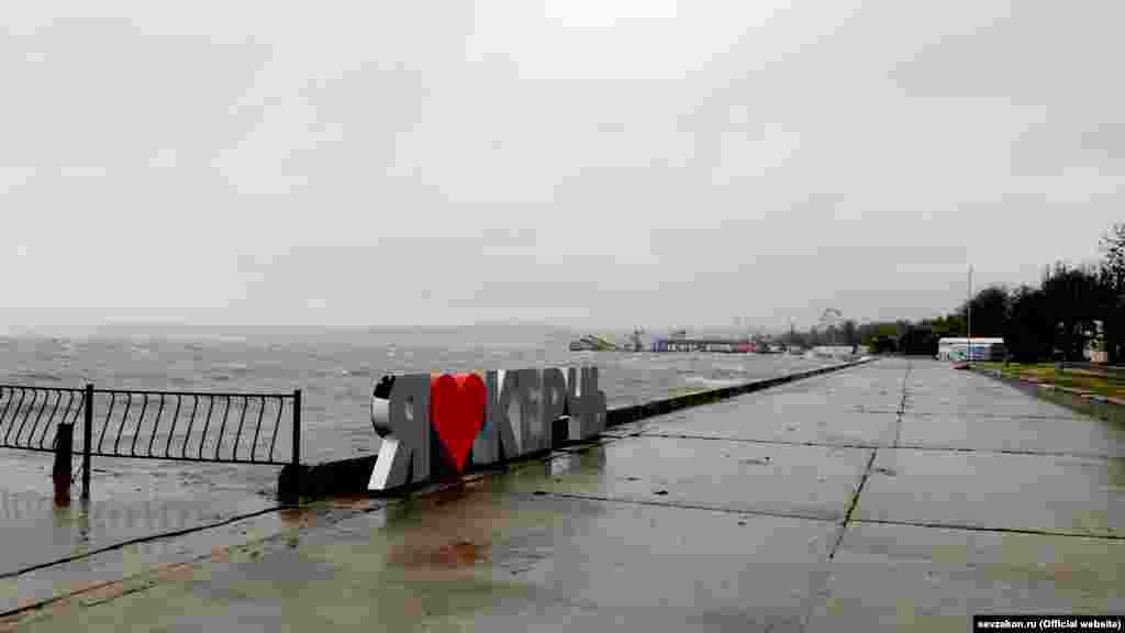 На городской набережной –  порывы шквального ветра, на море сильное волнение, волны захлестывают бетонное ограждение