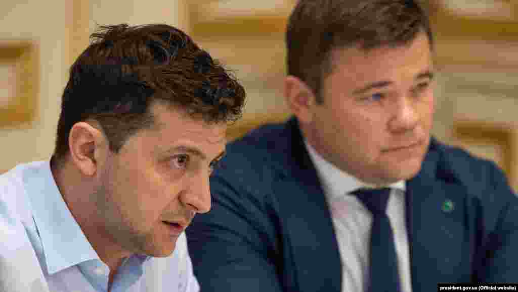 Володимир Зеленський та Андрій Богдан в Офісі президента. Призначення Андрія Богдана порушувало аж два положення закону України «Про очищення влади». Про це заявила голова Громадської ради з питань люстрації при Мін'юсті Тетяна Козаченко. Натомість у команді ж президента Володимира Зеленського наполягали, що призначення Андрія Богдана головою Адміністрації президента України не підпадало під закон, оскільки голова адміністрації не є державним посадовцем і не виконує жодних владних повноважень