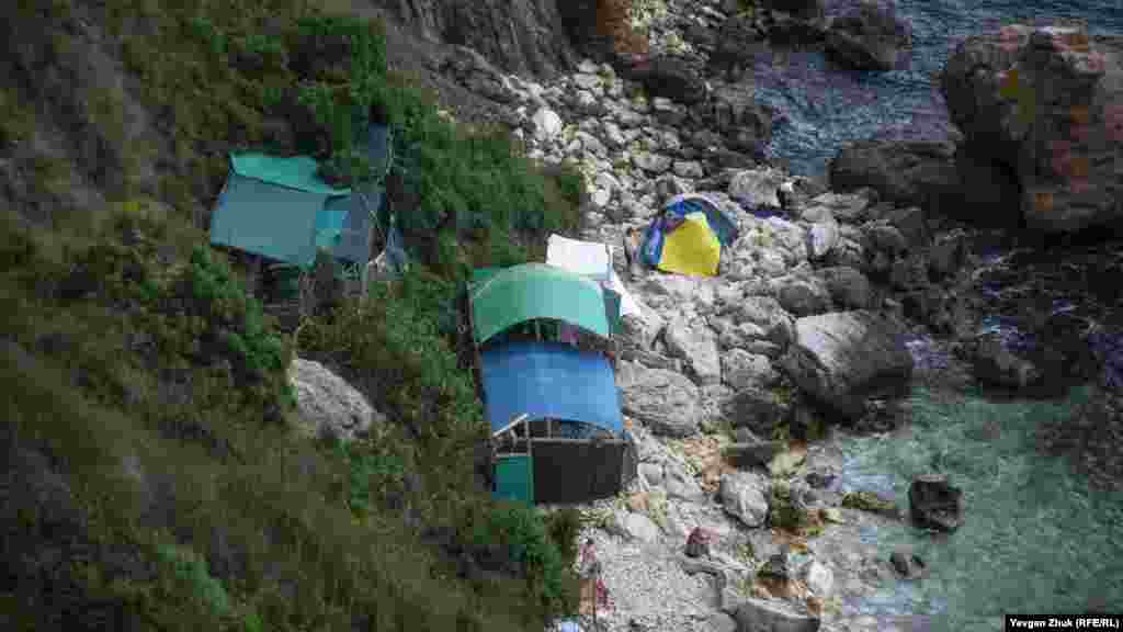 Всего в Крыму насчитывается порядка полутора тысяч активных оползней. Из них около 600 расположены в Большой Ялте. Еще около 120 оползней находятся вблизи Севастополя, большинство – на береговой линии. Крымские спасатели ранее обнародовали самые оползнеопасные места. В перечне – более трех десятков опасных точек вдоль Южного берега Крыма (от мыса Херсонес к мысу Фиолент и до бухты Ласпи, от мысов Ифигения, Кошка, Зеленого, Никита и ниже Кучук-Ламбадского хаоса), юго-восточного побережья (Алушта-Судак-Коктебель), западного побережья (от Радиогорки – Учкуевки и мыса Лукулл до поселков Угловое и Песчаное Бахчисарайского района, Берегового и Николаевки Симферопольского района и озера Кызыл-Яр Сакского района), а также Керченского полуострова. На фото: туристический лагерь прямо под скалами в районе базы отдыха «Каравелла» на мысе Фиолент, 16 июля 