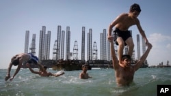 Пляж на Каспійському узбережжі в районі Баку. А на задньому плані нафтовидобувні платформи