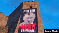 Плакат на стене замка в Нарве, 2025 год