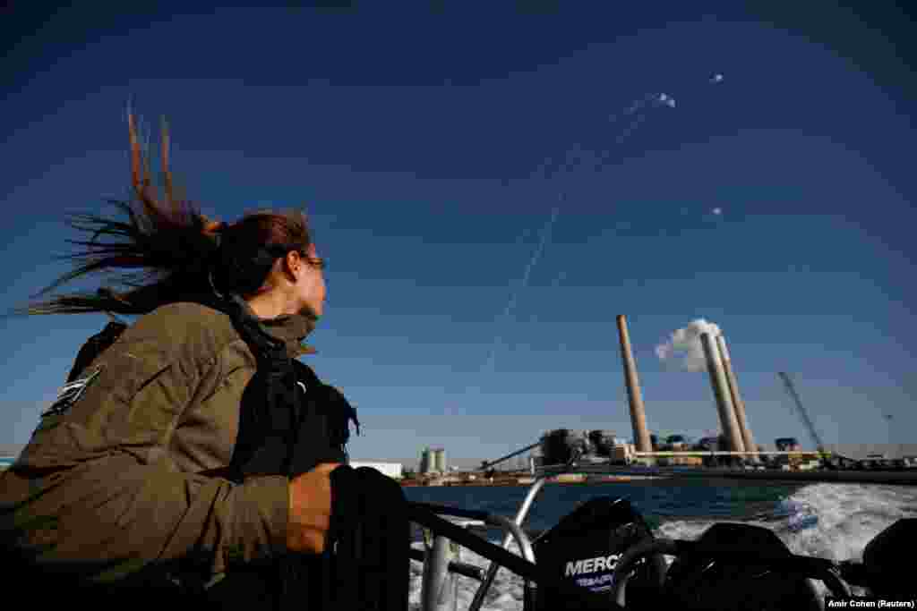 Ізраїльський солдат спостерігає, як ізраїльська протиракетна система «Залізний купол» перехоплює ракети, запущені зі Смуги Гази в напрямку Ізраїлю, як це видно з військового катера, який патрулює Середземне море біля південного узбережжя Ізраїлю