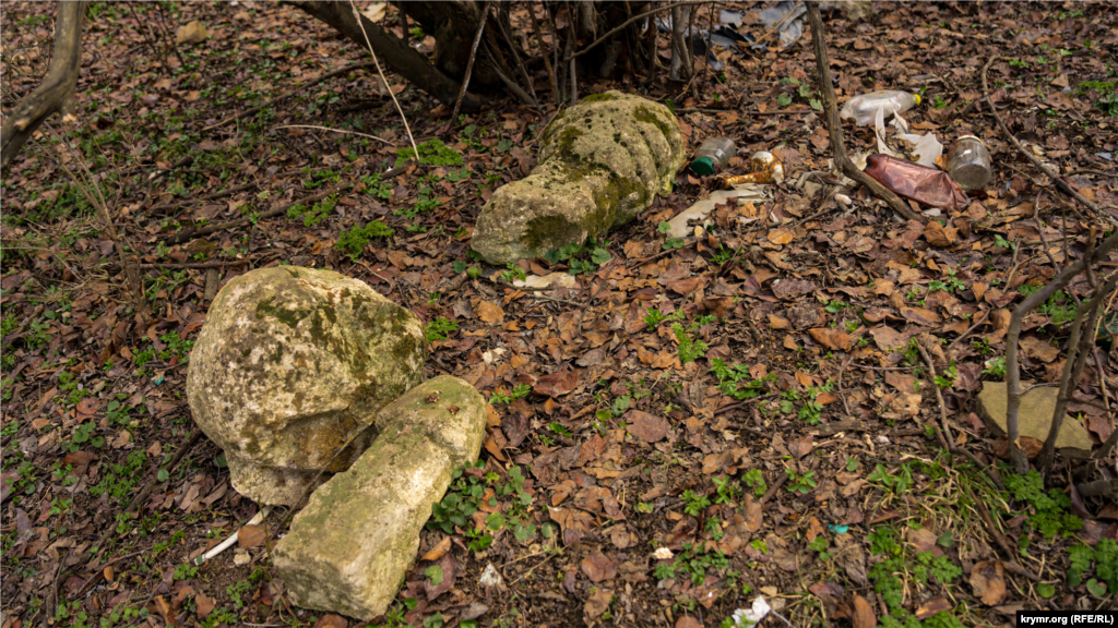 На нем видны несколько разбитых надгробий 