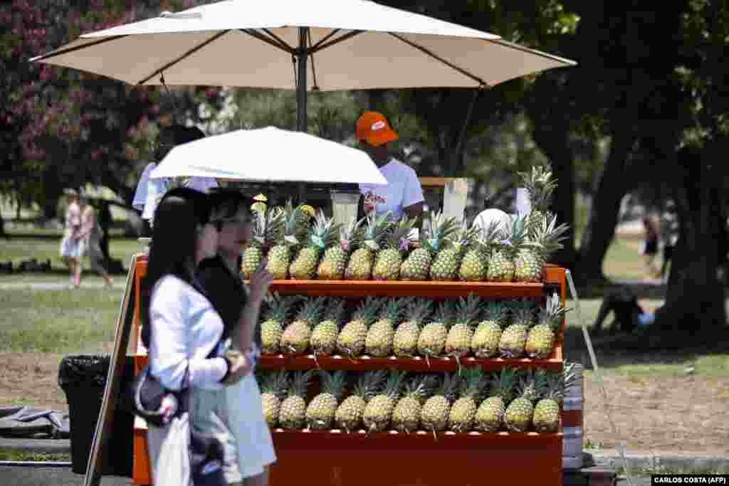 Dvije žene pod kišobranom kako bi se zaštitile od užarenog sunca u Lisabonu, Portugal, 29. juna.